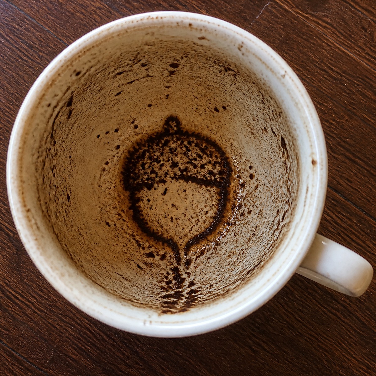 Emptied coffee cup with a coffee grounds symbol for tasseography reading
